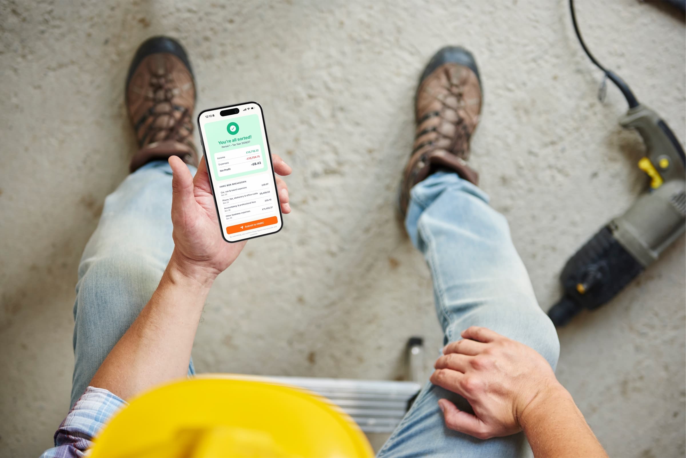 A tradesperson on site checking their quarterly figures in the Bosh app, ready to submit to HMRC